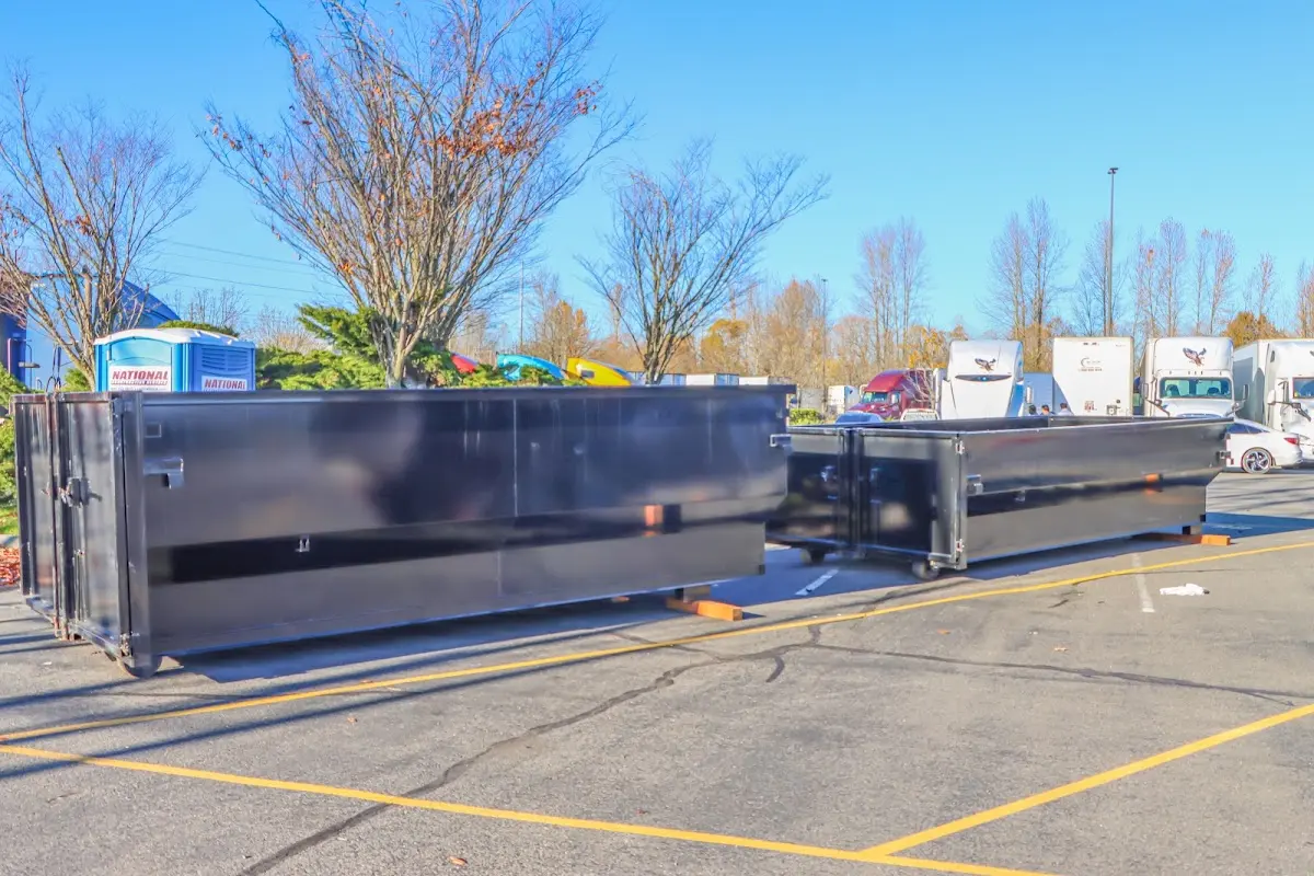 Professional dumpster rental service with roll-off container on residential driveway in Carlsbad